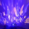 A night sky projector casting colorful ocean-themed images onto walls in a dark room. Voir les images du produit