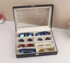 A black sunglasses organizer box with a clear lid, filled with various pairs of sunglasses. Voir les images du produit