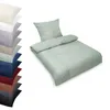 A stack of folded bedding in various colors is shown on the left, with a single set of mint green bedding displayed on the right. Produktbild-Vorschau