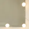 A close-up shot of a mirror with LED lights around the edge. Voir les images du produit