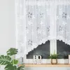 A white lace curtain with a floral pattern hangs in front of a window. A plant and decorative letters spelling 'HOME' are on the windowsill. Náhled obrázku produktu
