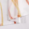 A close-up of a sheer curtain with orange and yellow stripes, layered over a page of text. Produktbild-Vorschau