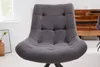 A close-up of a gray upholstered dining chair with tufted detailing. Produktbild-Vorschau
