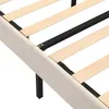 Close-up view of a bed frame with wooden slats and beige upholstered side rails. Náhled obrázku produktu