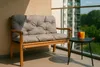 A grey cushion on a wooden bench on a balcony with drinks on a side table. Produktbild-Vorschau