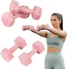 A woman is holding pink dumbbells while exercising, with other dumbbells in the background. Produktbild-Vorschau
