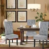 A dining room scene with chairs around a table, artwork on the wall, and a chandelier. Produktbild-Vorschau