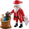 A Playmobil Santa Claus figure holding a teddy bear and a wish list, with a sack of toys. Náhľad obrázku produktu