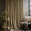A cozy corner with a large beige curtain, a chair with throws, and decorative items. Anteprima dell’immagine prodotto