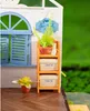 A miniature house with a window, a shelf with plants and storage boxes, and a flower in a pot on the floor. Anteprima dell’immagine prodotto