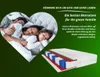 A family sleeping in a heart-shaped frame, with a cutaway view of a mattress below. Produktbild-Vorschau