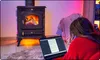 A person is working on a laptop in front of a wood-burning stove. Voir les images du produit