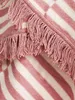 A close-up view of a fluffy blanket with pink and white stripes and fringe. Produktbild-Vorschau