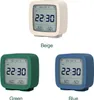 Three different colored alarm clocks are displayed side-by-side, each with a digital display showing the time, date, and temperature/humidity. Podgląd zdjęcia produktu