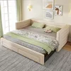 A beige upholstered daybed with green and patterned bedding is shown in a room with light green curtains and artwork on the wall. Náhled obrázku produktu
