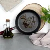 A cast iron pan with oil in it, a bottle of olive oil, and a kitchen towel. Produktbild-Vorschau