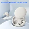 A pair of beige wireless earbuds and their charging case are displayed against a soft, abstract background. Produktbild-Vorschau