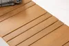 A close-up of a wooden bench with a folded blanket on top. Produktbild-Vorschau