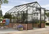 A greenhouse filled with plants, situated on a patio next to a house. Náhled obrázku produktu