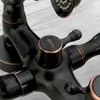 Close-up of a black and bronze faucet with a shower head visible in the background. Anteprima dell’immagine prodotto