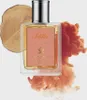 A perfume bottle is presented with artistic elements like wood and smoke-like clouds. Voir les images du produit