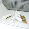 A close-up shot of electrical enclosure accessories, including mounting brackets, screws, and round spacers, placed on a white surface. Produktbild-Vorschau
