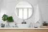 A modern bathroom vanity with a sink, mirror, and various decorative items. Produktbild-Vorschau