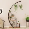 A modern plant stand with multiple shelves, holding various potted plants, in a room with a beige wall and a cream-colored armchair. Produktbild-Vorschau