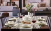 A formal dining table set for a meal, with plates, cutlery, glasses, and candles. Náhľad obrázku produktu