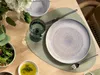 A table setting with plates, cutlery, a glass of water, and a salad. Produktbild-Vorschau