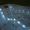 An outdoor whirlpool at night, illuminated by internal blue lights. Podgląd zdjęcia produktu