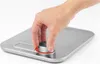 A hand is shown turning a dial on a kitchen scale. Anteprima dell’immagine prodotto