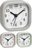 A collage of three small alarm clocks in different pastel colors: gray, pink, and green. The gray clock is shown larger and in focus, while the pink and green clocks are smaller and in the background. Produktbild-Vorschau