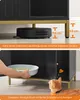A cat cabinet with a robot vacuum underneath and a person placing a litter box inside, with a cat looking on. Produktbild-Vorschau