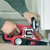 A person is using a belt sander to sand a piece of trim in a room. Anteprima dell’immagine prodotto