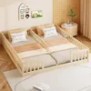 Two children's beds are placed side-by-side in a room with a light-colored rug and wooden floor. There are decorative pictures on the wall and a small side table with a plant and books. Anteprima dell’immagine prodotto