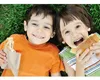 Two children lying on grass and eating sandwiches. Produktbild-Vorschau
