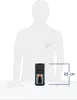 A silhouette of a person is shown with a coffee machine and a glass of coffee in front of them, indicating the size of the machine. Produktbild-Vorschau