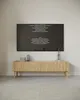 A modern living room with a TV mounted on the wall above a wooden media console. Náhled obrázku produktu
