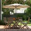 A patio set with a large umbrella in a backyard setting. Náhled obrázku produktu