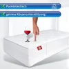 A hand is pressing down on a mattress, with a wine glass nearby, demonstrating its support and elasticity. Produktbild-Vorschau