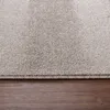 A close-up view of a carpet edge resting on a wooden floor. Podgląd zdjęcia produktu