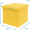A yellow fabric storage ottoman with dimensions indicated. Produktbild-Vorschau