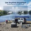 A portable cooler and solar panel setup by a lake with a car and canoe. Produktbild-Vorschau
