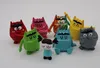 A collection of colorful monster figurines and a small human figurine arranged on a white background. Produktbild-Vorschau