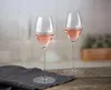 Two glasses of rosé wine on a wooden table with a dark gray napkin. Podgląd zdjęcia produktu