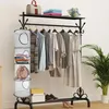 A clothing rack with hanging clothes and storage bins, along with some accessories on a shelf and the floor. Produktbild-Vorschau