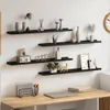 A wall with four black shelves displaying various decorative items and a desk with office supplies below. Podgląd zdjęcia produktu