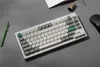 A keyboard, pen, and film roll are arranged on a gray surface. Produktbild-Vorschau