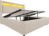A beige upholstered double bed with its hydraulic lift mechanism open, revealing storage space underneath. The headboard has integrated LED lighting. Náhled obrázku produktu